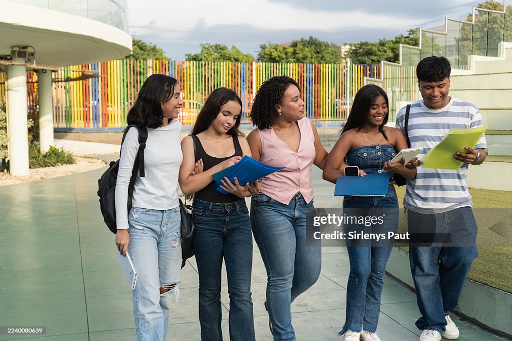 Diverse high school students walking on campus discussing studies
