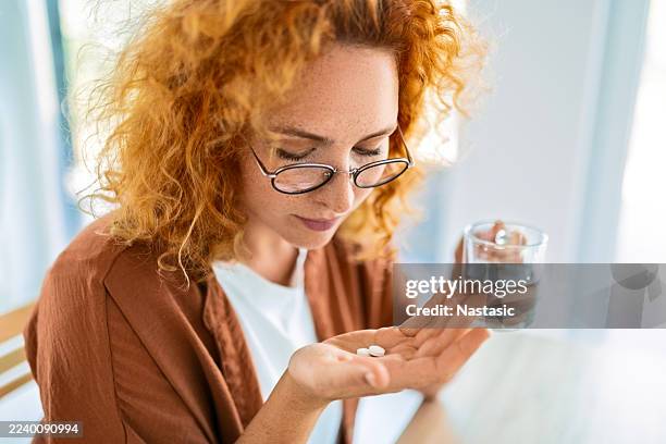 weiblich, die sich auf die einnahme von medikamenten vorbereitet - tabletten schlucken stock-fotos und bilder