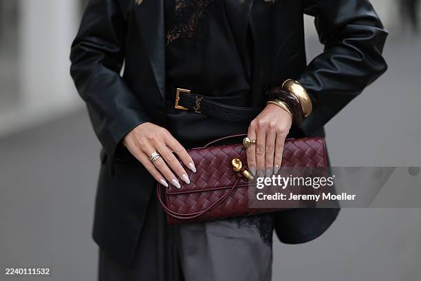 Olga Liber with long, softly waved blonde hair worn in a center part, seen wearing a black satin lace camisole paired with loose charcoal silk...