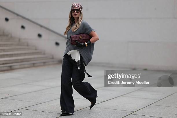 Olga Liber with blonde wavy hair seen wearing a Zara look featuring a grey oversized knit vest layered over a white satin lace-trim camisole and...