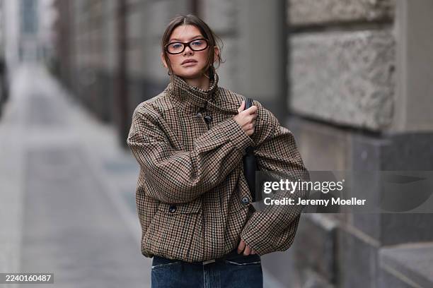 Sophia Geiss is wearing a checked oversized jacket from Eleh with a high collar and voluminous sleeves, paired with wide-leg dark blue jeans from...