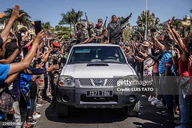 Members of Madagascar's CAPSAT army unit patrol on a pickup truck as they are greeted with jubilation by residents gathered for ceremony honouring...