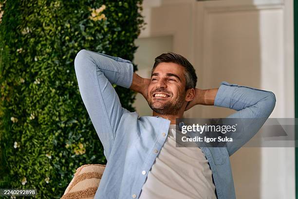 man relaxing with hands behind head, enjoying comfort - composition stock pictures, royalty-free photos & images