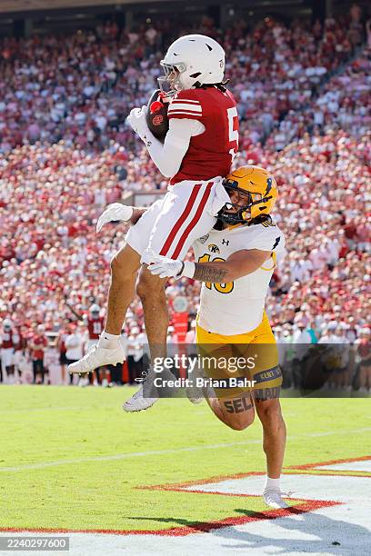 Wide receiver Isaiah Sategna III of the Oklahoma Sooners catches a 30-yard pass for a touchdown against linebacker Canaan Williams of the Kent State...