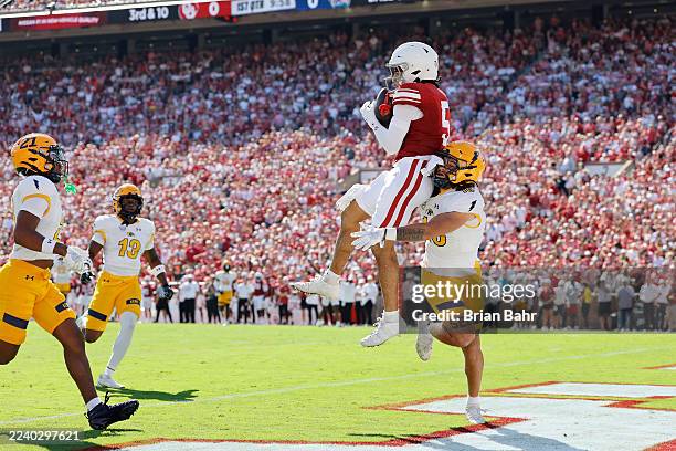Wide receiver Isaiah Sategna III of the Oklahoma Sooners catches a 30-yard pass for a touchdown against linebacker Canaan Williams of the Kent State...