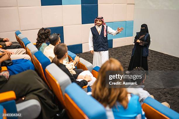 engaged tourists attending informative session at rijal almaa village museum auditorium - education building stock pictures, royalty-free photos & images
