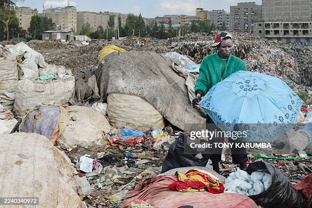 Kenyan fashion designer specialising in upcycling discarded fabrics and garments, Morgan Azedy rummages through piles of discarded garments at a...