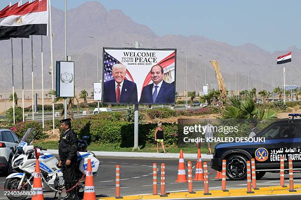 Tourists take pictures in front of a billboard bearing the portraits of US President Donald Trump and Egyptian President Abdel Fattah al-Sisi outside...