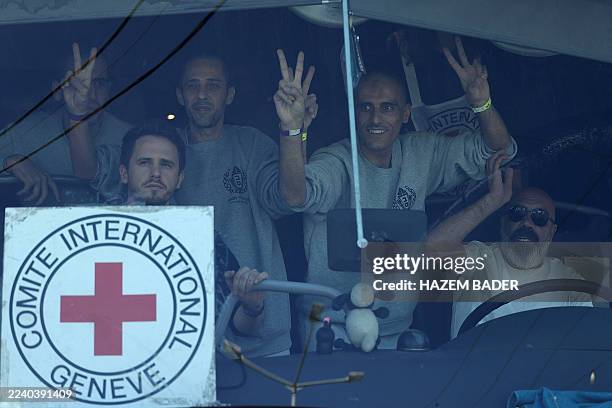 Palestinian men gesture from inside a bus after being released from the Ofer military prison located between Ramallah and Beitunia in the occupied...