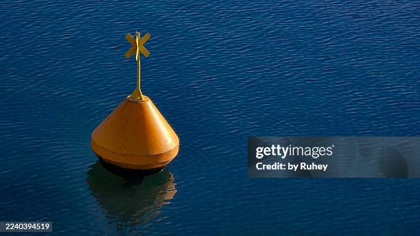 yellow buoy isolated on calm blue water - boia equipamento marítimo de segurança imagens e fotografias de stock