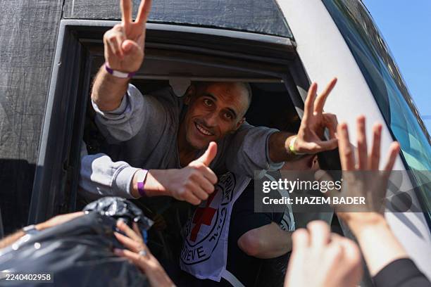 Palestinian men gesture from inside a bus after being released from the Ofer military prison located between Ramallah and Beitunia in the occupied...