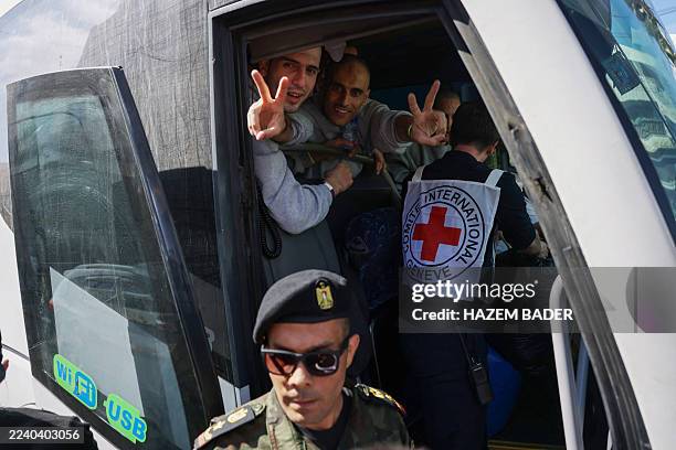 Palestinian men gesture from inside a bus after being released from the Ofer military prison located between Ramallah and Beitunia in the occupied...