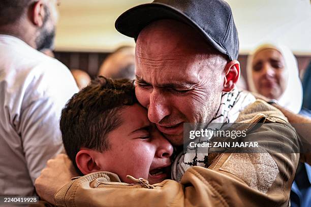 One of the Palestinian prisoners, who was released in a prisoner-hostage swap and ceasefire deal between Israel and Hamas, embraces a boy upon...