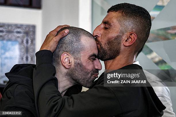 One of the Palestinian prisoners, who was released in a prisoner-hostage swap and ceasefire deal between Israel and Hamas, is kissed by his brother...