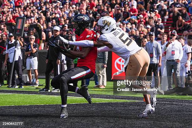 Wide receiver Jeff Caldwell of the Cincinnati Bearcats catches a pass for a touchdown while being guarded by defensive back DJ Bell of the UCF...