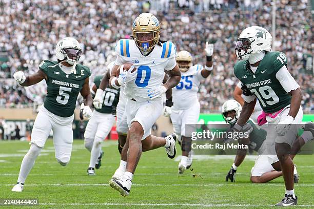 Jalen Berger of the UCLA Bruins rushes for a touchdown during the first half against the Michigan State Spartans at Spartan Stadium on October 11,...