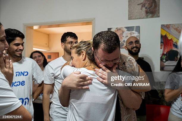 Two family members hug each other while waiting at Hostages Square in Tel Aviv, Israel, on October 13 as relatives and friends gather to watch the...