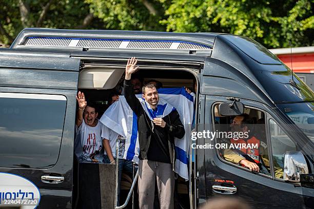 Released hostage Guy Gilboa Dalal is escorted into Beilinson Hospital in Israel on October 13 while greeting the crowd gathered to witness his...