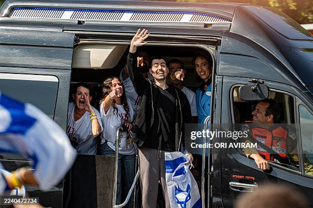Released hostage Guy Gilboa Dalal is escorted into Beilinson Hospital in Israel on October 13 while greeting the crowd gathered to witness his...