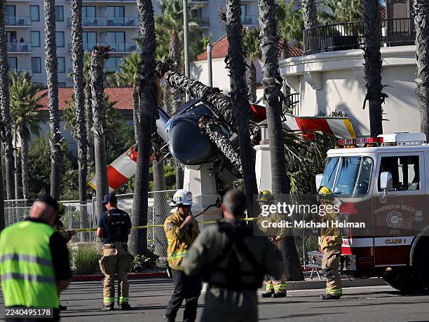 First responders are seen in front of a helicopter that crashed on Pacific Coast Highway on October 11, 2025 in Huntington Beach, California. Two...