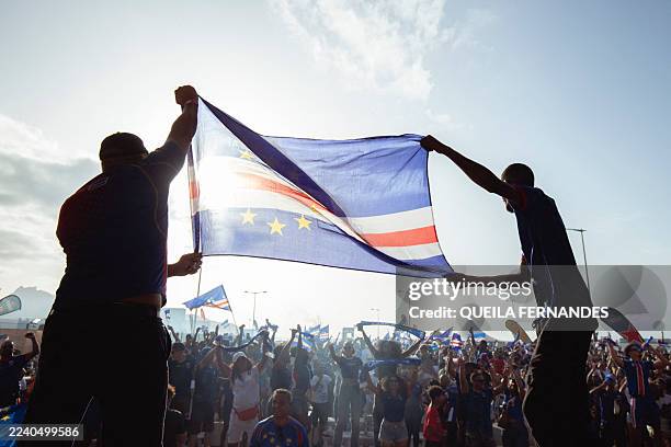 Supporters celebrate Cape Verde's victory against Eswatini during the FIFA World Cup 2026 Africa qualifiers group D match at a fan zone in Sao...