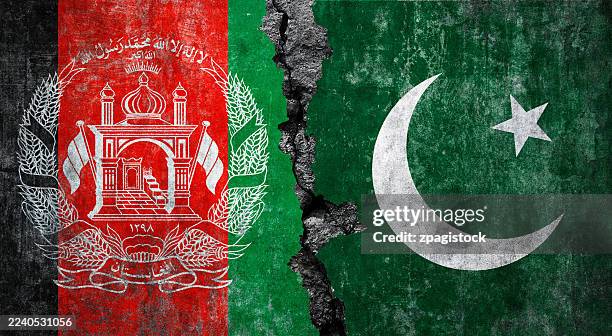 afghan and pakistani flag on cracked wall surface: afghanistan - pakistan relations: tensions, geopolitics crisis, - pakistani flag stock pictures, royalty-free photos & images