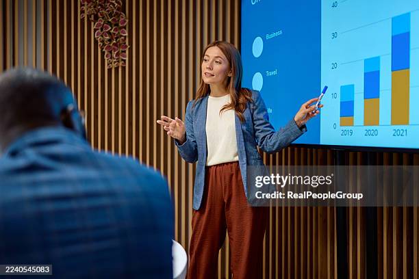 woman presenting business data using chart on screen - presentatie stockfoto's en -beelden