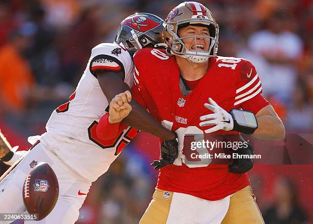 Mac Jones of the San Francisco 49ers fumbles after being hit by Jamel Dean of the Tampa Bay Buccaneers during the first quarter in the game at...