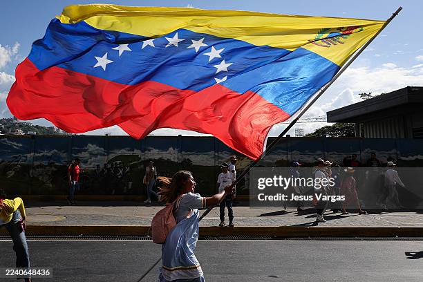 An indigenous woman waves a Venezuelan flag during a rally to commemorate Indigenous Resistance Day on October 12, 2025 in Caracas, Venezuela.