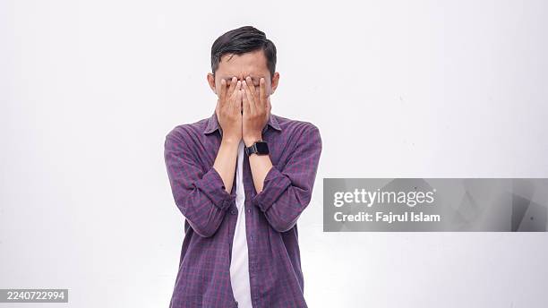 asian man with disappointed face against white background - grumpy face stock pictures, royalty-free photos & images