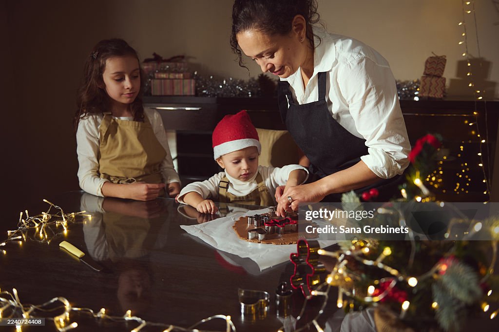 Family Christmas Baking Scene With Mother And Children Decorating Cookies