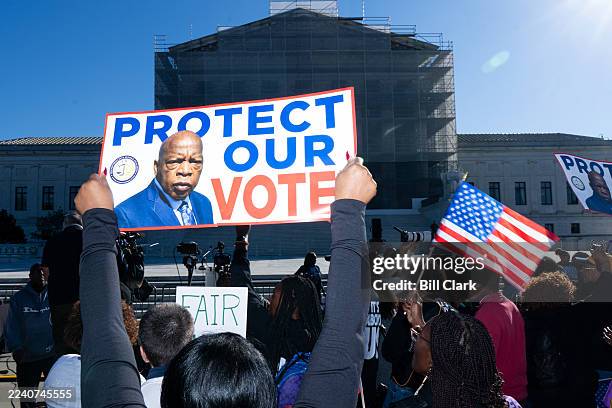 Voting rights activists protest outside the U.S. Supreme Court as the court prepares to hear arguments in a case challenging Louisiana's...
