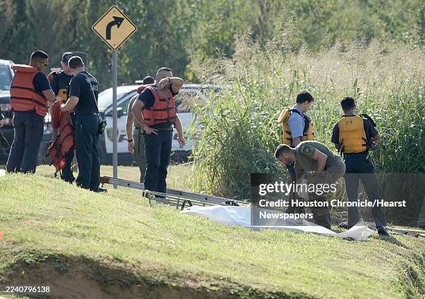 Houston fire and police personnel work to recover a body from White Oak Bayou near the Heights in Houston, Wednesday, Oct. 8, 2025.
