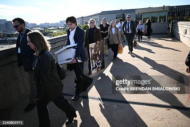 Reporters carry their belongings from the Pentagon in Washington, DC, on October 15, 2025 after US and international news outlets including The New...