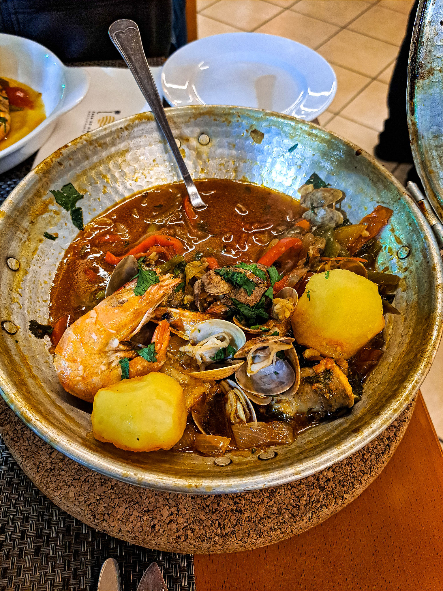Traditional portuguese dish Cataplana cooked and served in a domed copper pot. Algarve, southern Portugal Traditional portuguese dish Cataplana cooked and served in a domed copper pot. Algarve, southern Portugal