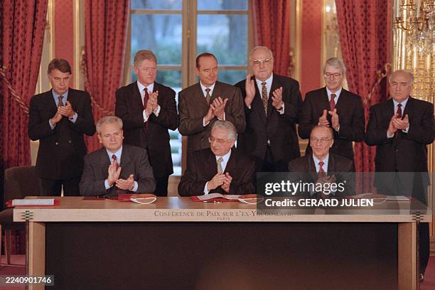 Serbian President Slobodan Milosevic, Croatian President Franjo Tudjman and Bosnian President Alija Izetbegovic applaud after signing the peace...