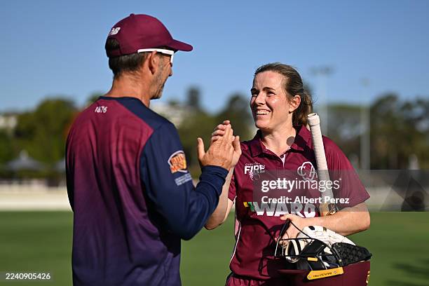 Georgia Redmayne of Queensland celebrates with Queensland head coach Mark Sorell after their victory during the WNCL match between Queensland and ACT...