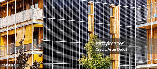 sustainable urban housing with integrated photovoltaic panels facade and timber design - building integrated photovoltaics stock pictures, royalty-free photos & images