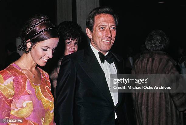 Franco-American singer, actress and dancer Claudine Longet, wearing a pink, yellow and red outfit, and her husband, American singer Andy Williams,...