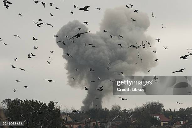 Powerful explosion erupts on the horizon as birds fly over destroyed buildings damaged by artillery fire in the frontline city of Kostiantynivka on...