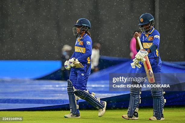 Sri Lanka's Harshitha Samarawickrama and Kavisha Dilhari leave the field as rain stops play during the ICC Women's Cricket World Cup 2025 one-day...