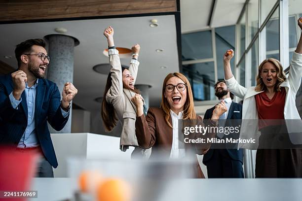 business team cheering celebrating success in modern office - cheering stock pictures, royalty-free photos & images