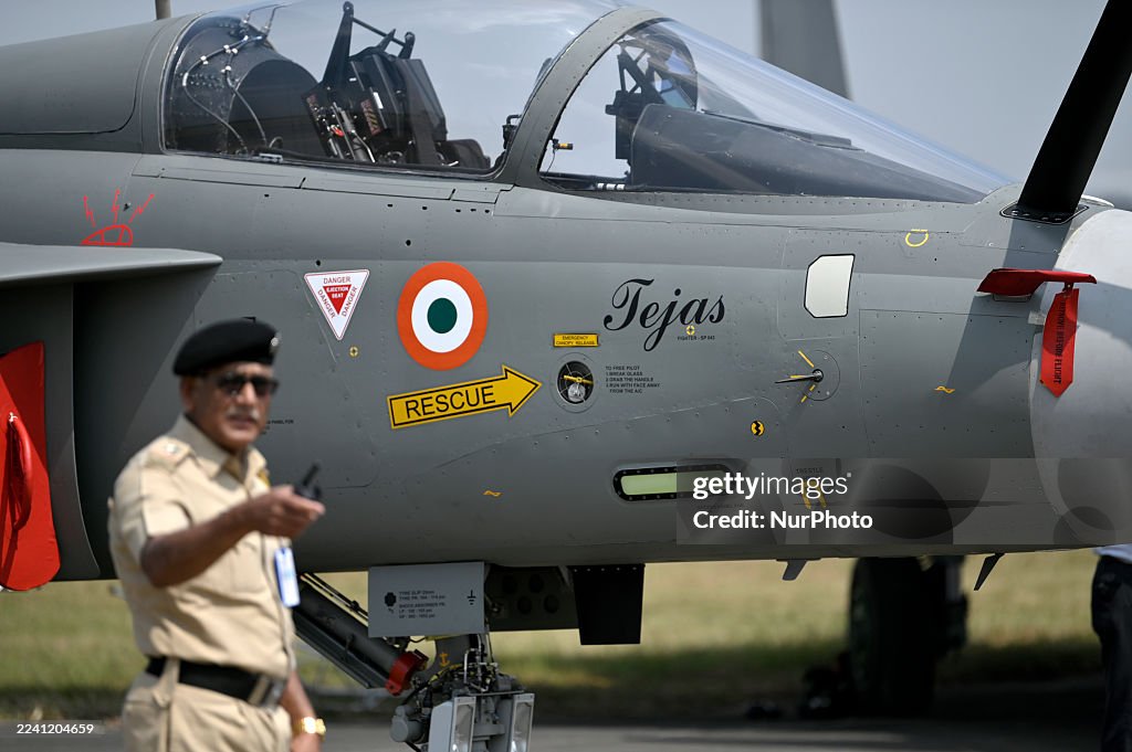 Hal Press A policeman gestures in front of the cockpit of an Indian Air Force ...