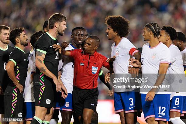 Referee Kwinsi Williams breaks up an argument between Cameron Burgess of Australia and Chris Richards of the United States during the first half at...