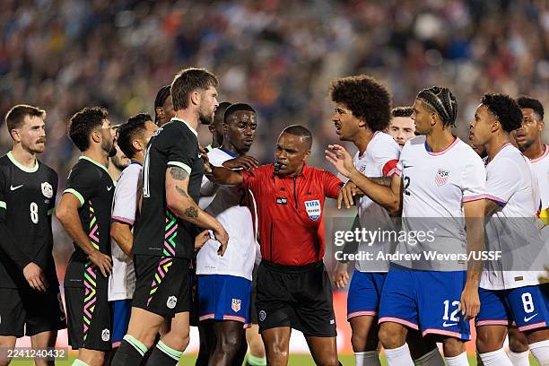Referee Kwinsi Williams breaks up an argument between Cameron Burgess of Australia and Chris Richards of the United States during the first half at...