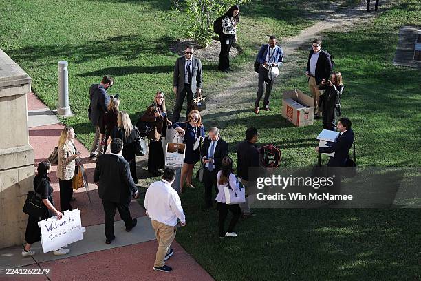 Pentagon reporters walk out of the building carrying their belongings after turning in their press badges October 15, 2025 in Arlington, Virginia....