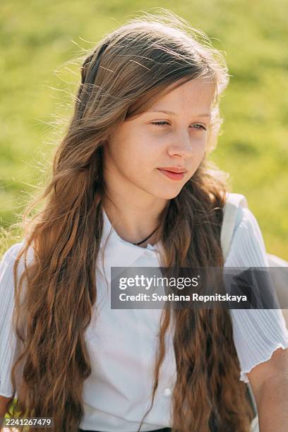 thoughtful young girl with long hair outdoors in sunlight - caucasian 11 12 girl portrait vertical beautiful stock pictures, royalty-free photos & images