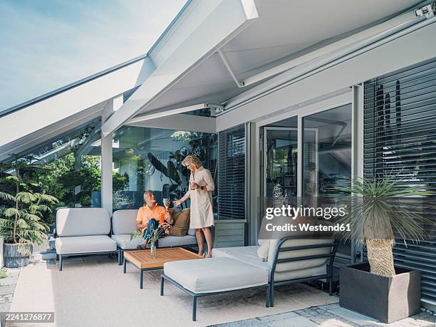 seniors relaxing on a modern patio lounge with awning at home - awning stock pictures, royalty-free photos & images
