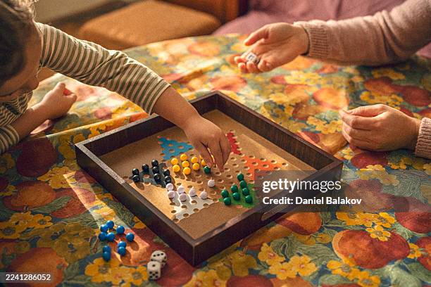family care. playing board game and sharing fun moments - bordspel stockfoto's en -beelden