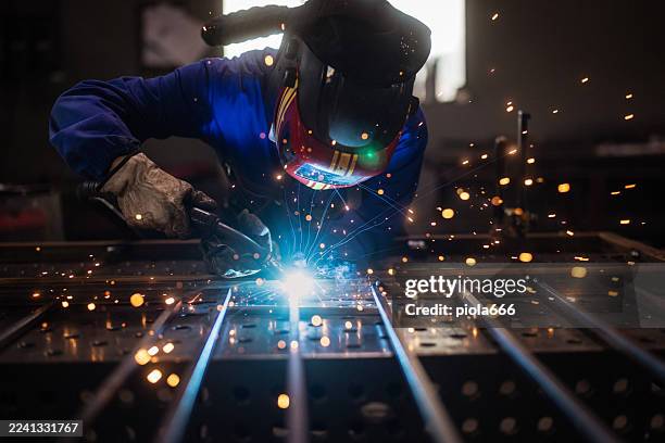 metalworker grinding iron fence with sparks - metaalbewerking stockfoto's en -beelden